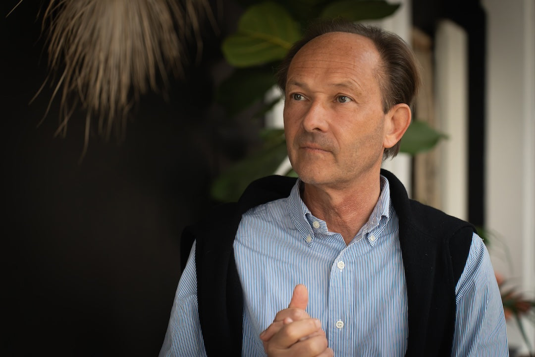 Photo d'un homme brun avec une chemise bleue rayée